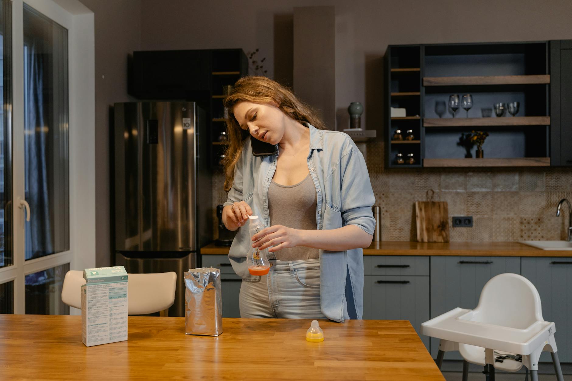 Mama przygotowuje mleko modyfikowane w nowocześnie urządzonej kuchni