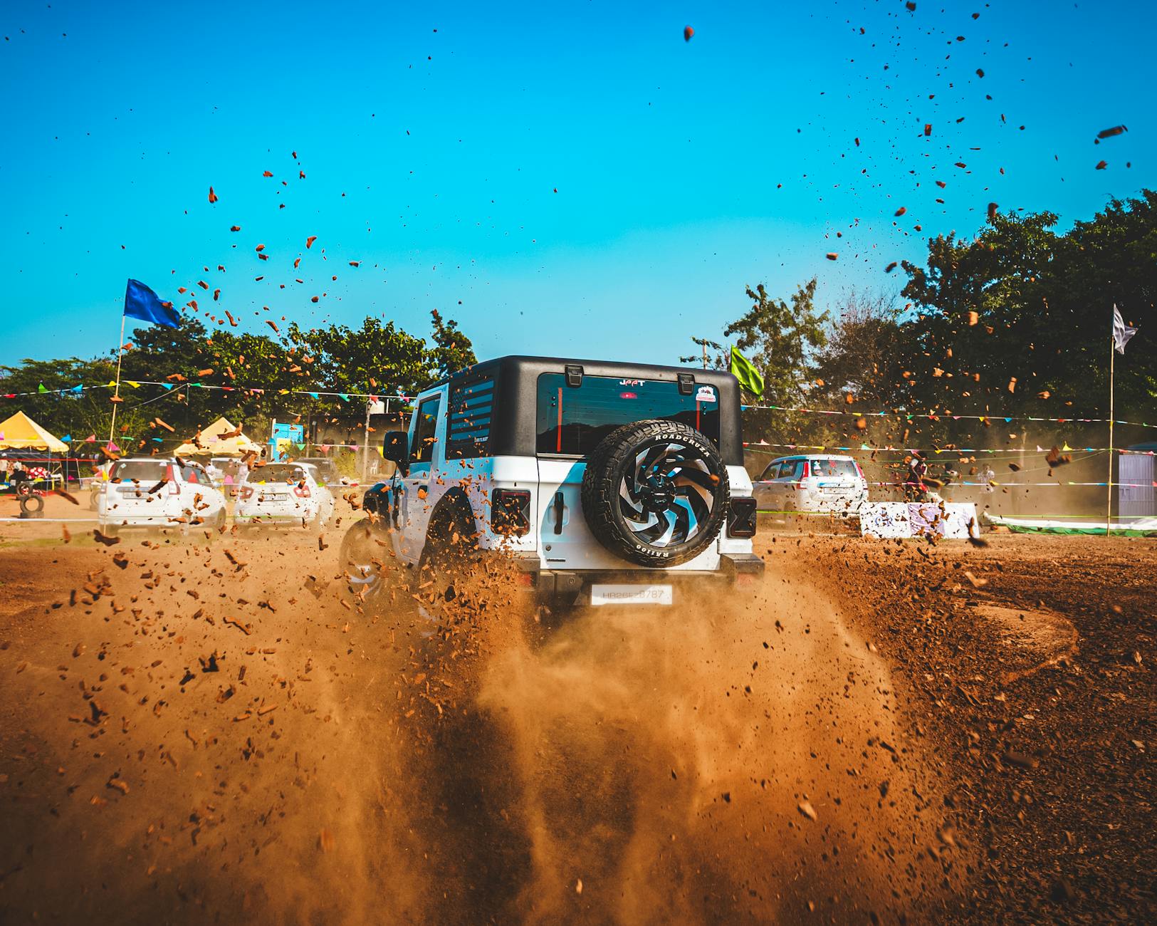 SUV terenowy jadący po zakurzonej, polnej drodze podczas off-roadu