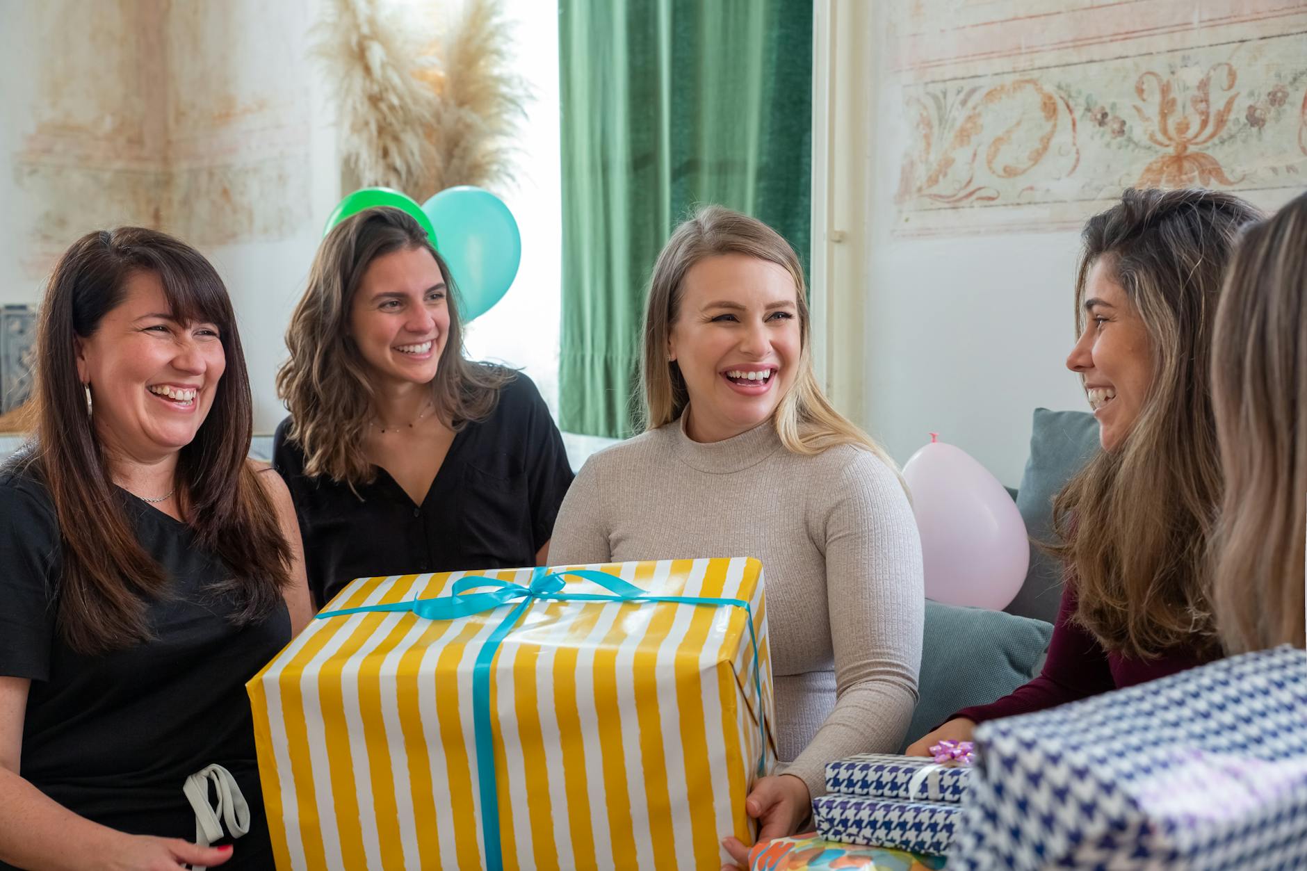 Lista gości na baby shower kogo zaprosić a kogo lepiej pominąć bez poczucia winy Cztery kobiety świętują baby shower, wręczając przyszłej mamie prezenty