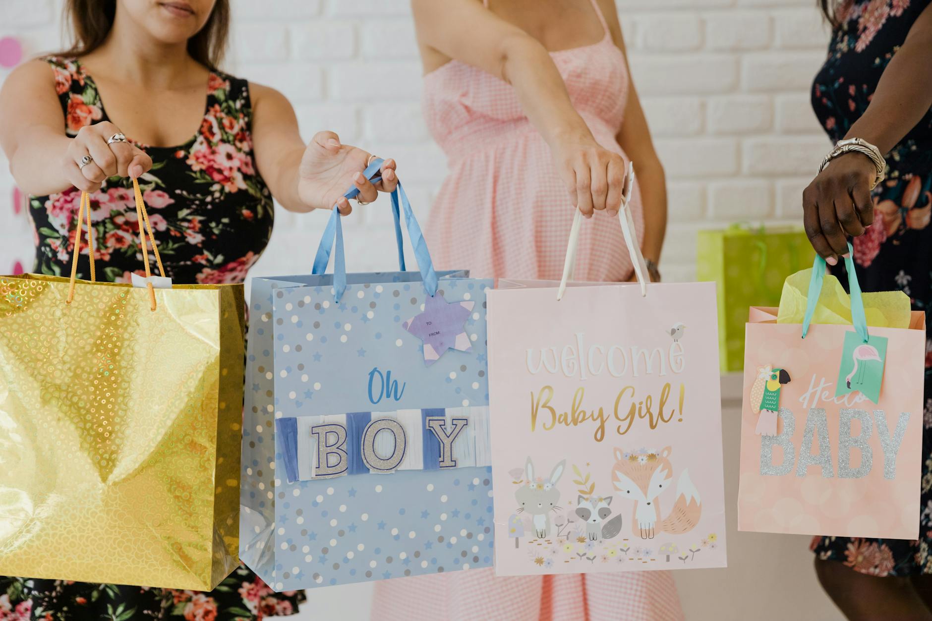 Kobiety trzymają kolorowe torby z prezentami na baby shower