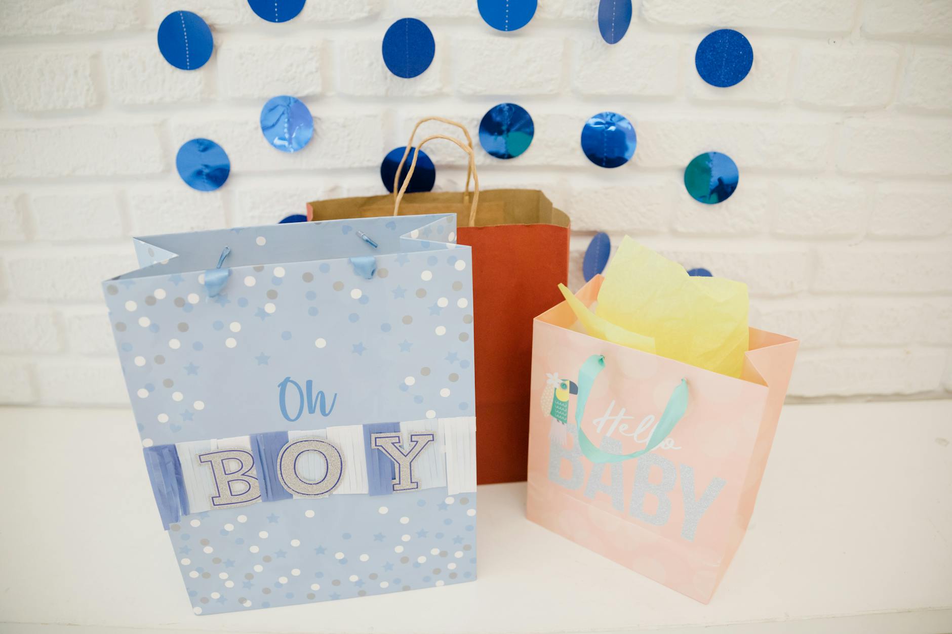 Zabawki na Baby Shower: jak wybrać prezenty rozwijające, a jednocześnie przyjazne dla świeżych rodziców Kolorowe torby prezentowe i dekoracje na baby shower dla chłopca