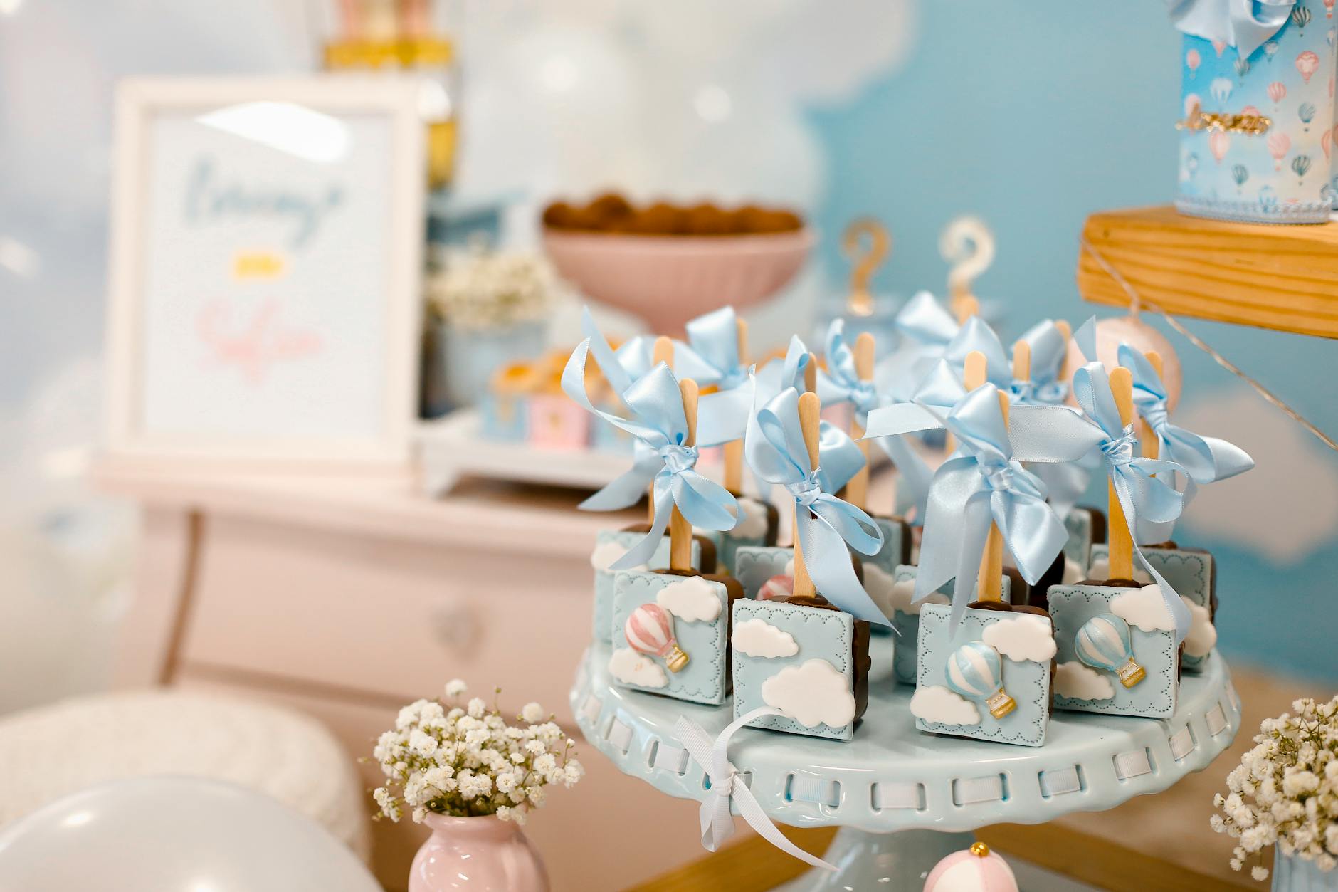 Stół z deserami na baby shower udekorowany w pastelowych kolorach