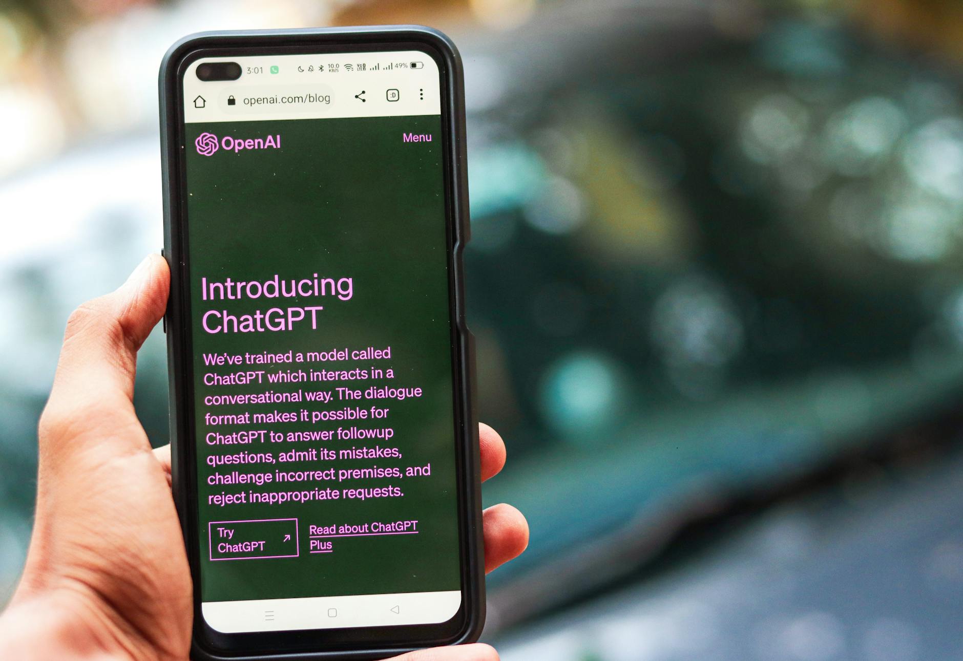 Telefon w dłoni z wyświetlonym profilem ChatGPT na stronie OpenAI