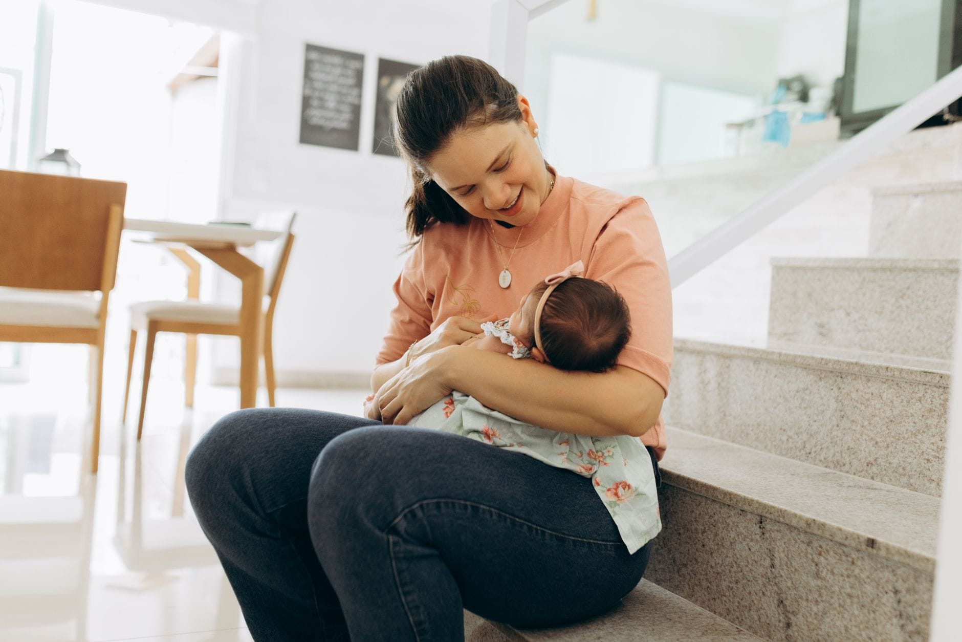 Mama z niemowlęciem na schodach w domu