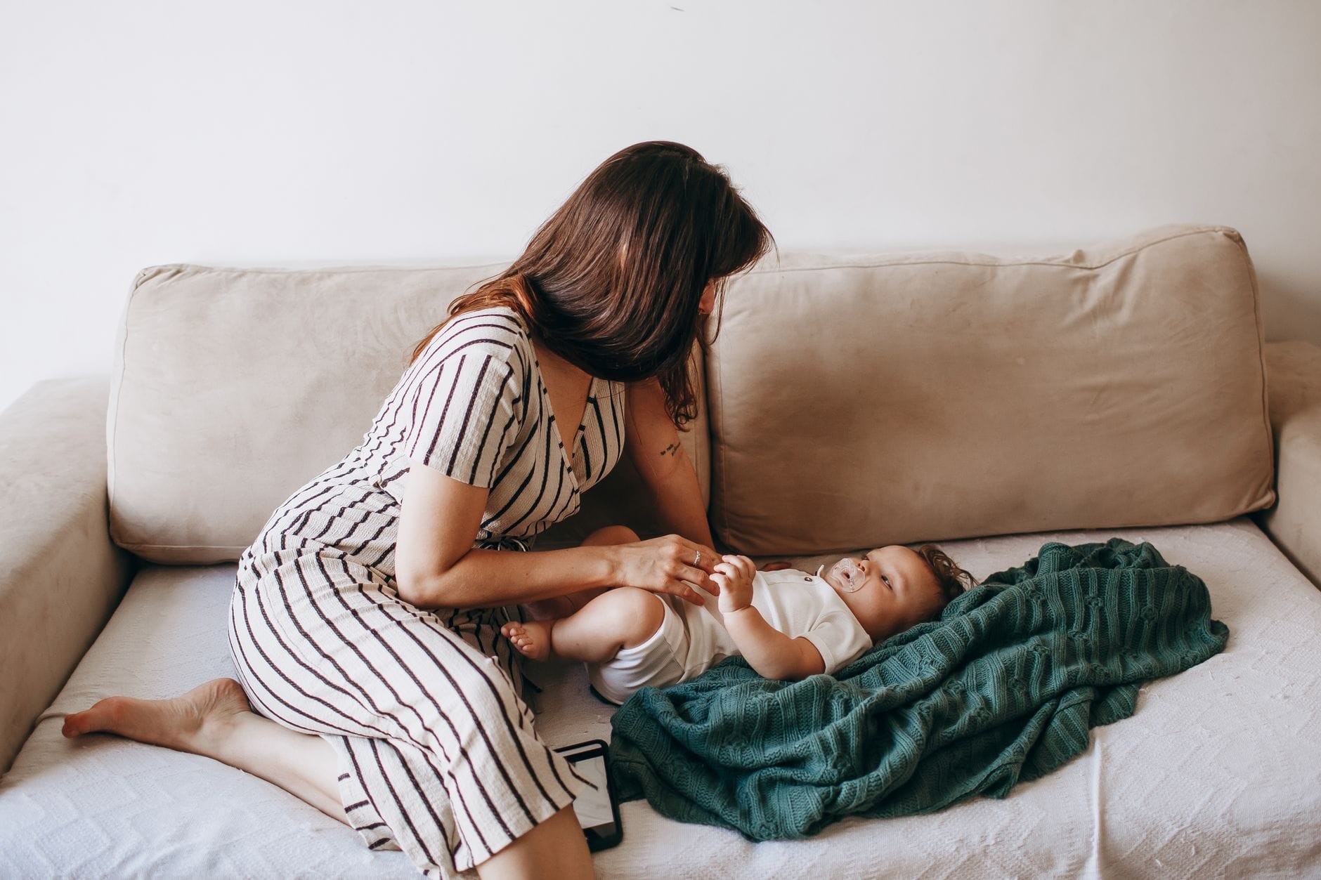 Mama z niemowlęciem odpoczywają razem na kanapie w domu