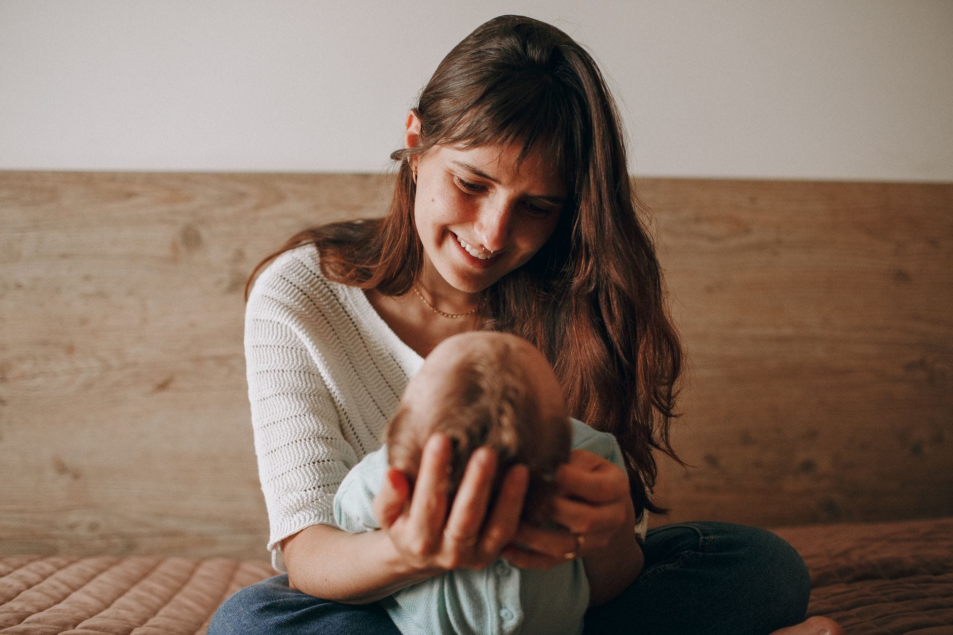 Mama tuląca niemowlę w domu podczas wspólnej podróży
